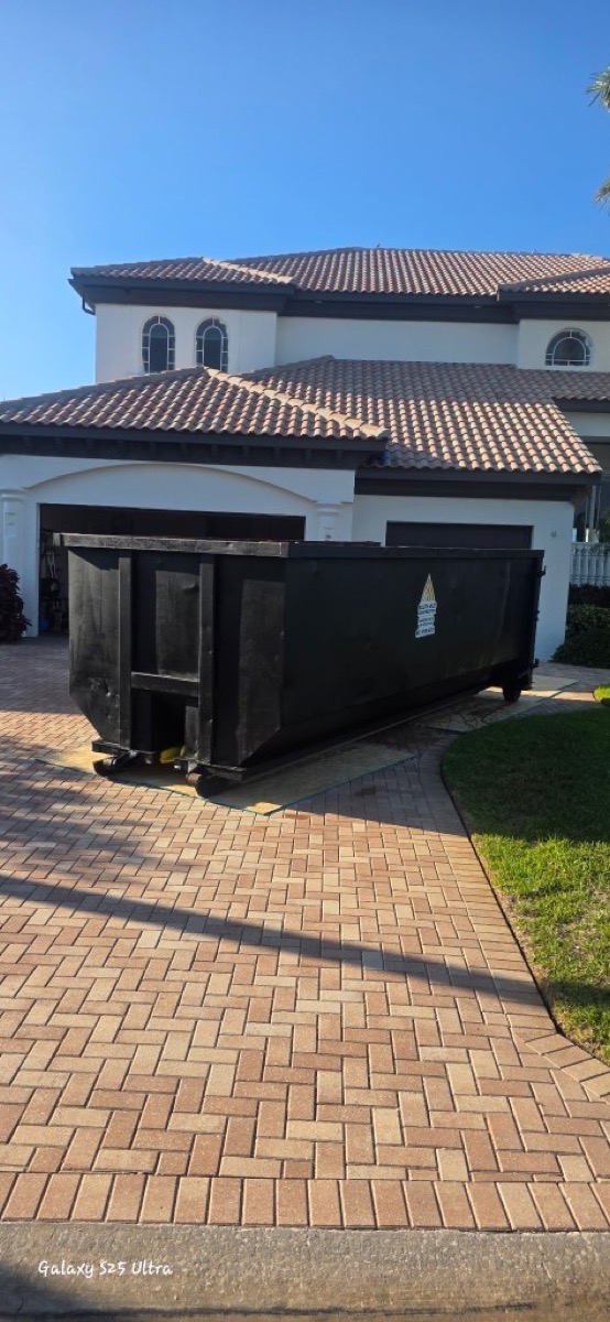 Roll-off dumpster on a paver driveway in Tampa